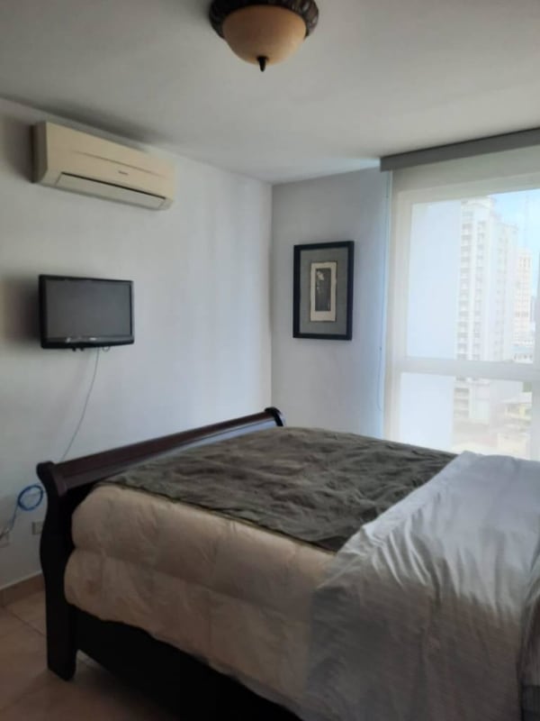 Bedroom with cityscape view white bedding at PH El Cangrejo Panama City