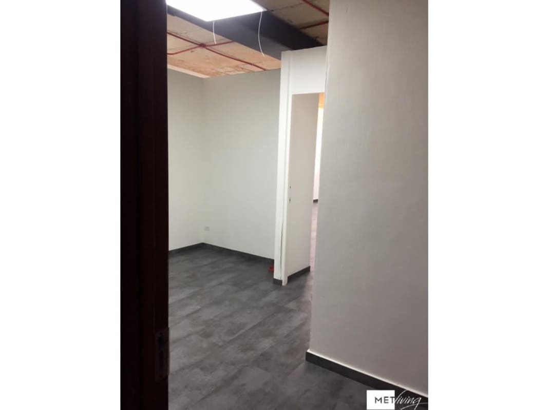 Unfinished industrial-style open commercial office with tile flooring and exposed ceiling in Panama