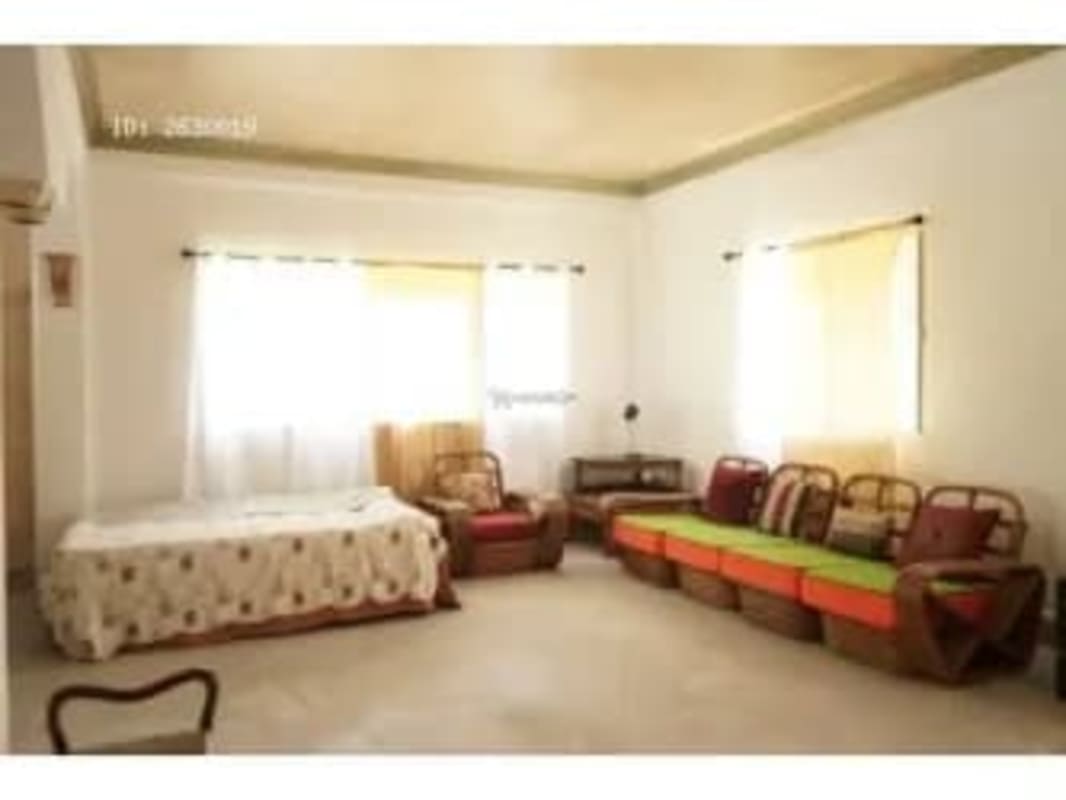Living room with red accent wall, mirror, entertainment center and bright lighting