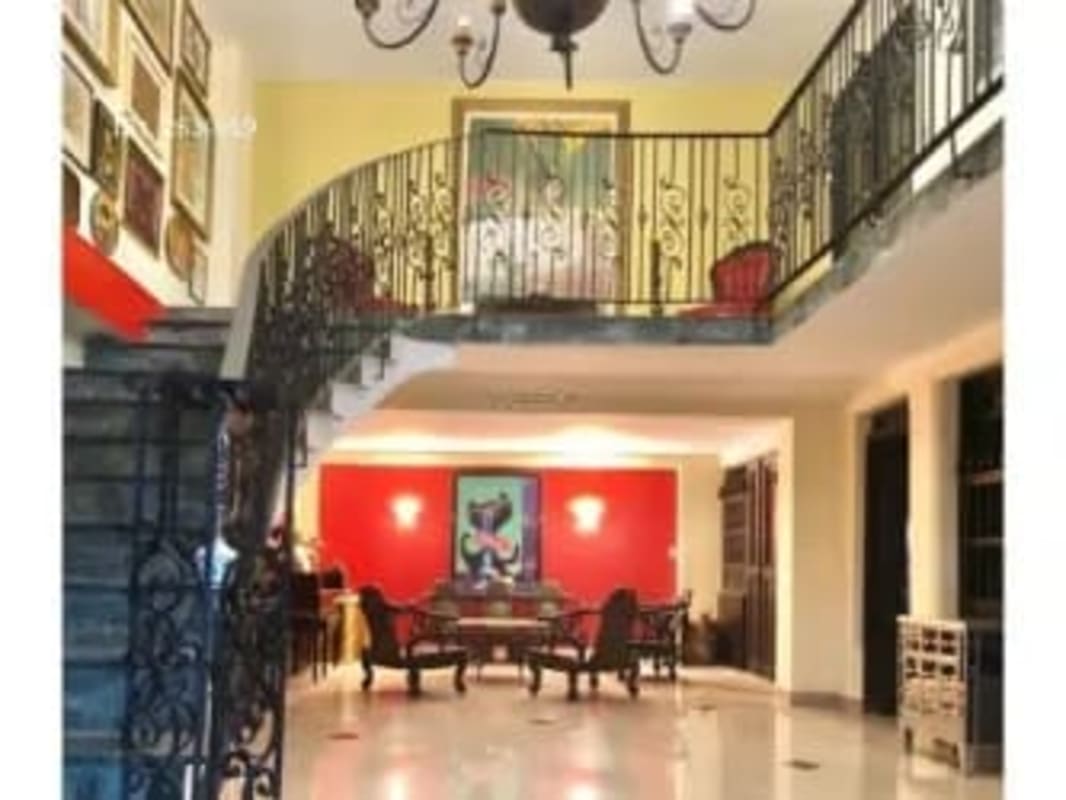 Grand staircase foyer with chandelier, iron railing, gallery art in Albrook Clayton home