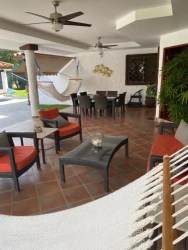 Covered patio dining lounge with hammock ceiling fans near garden beach estate Panama