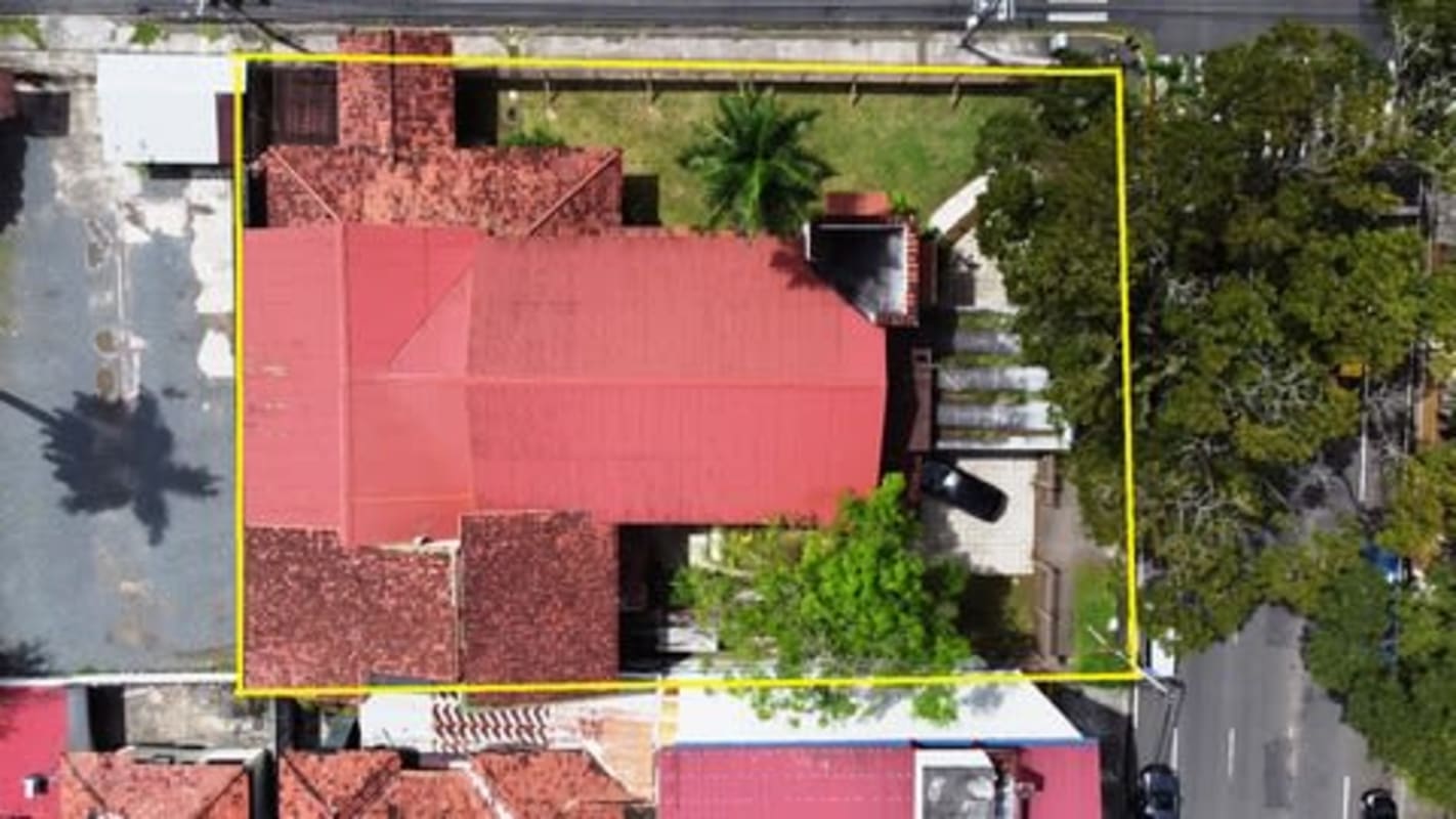 White stucco facade with arches, red tile roof historic Spanish Colonial building in Panama City Calidonia