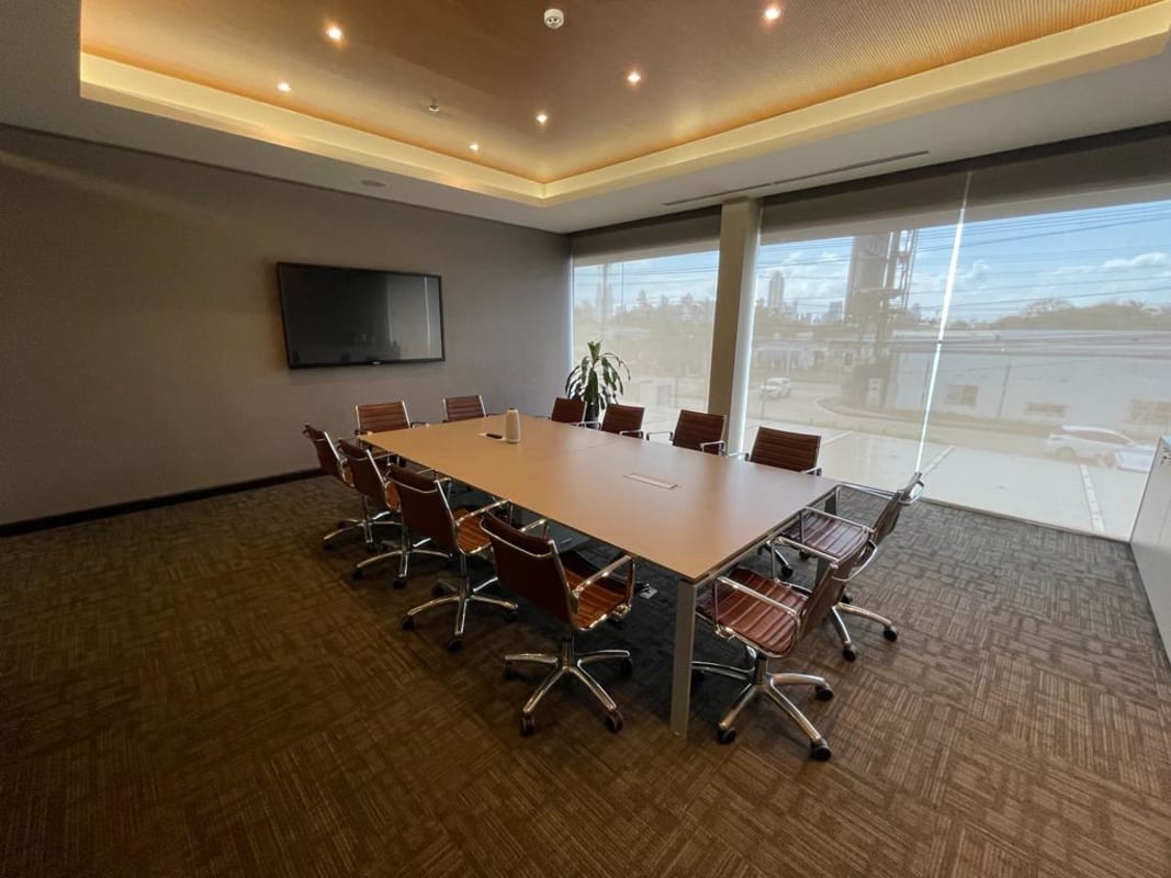 Large conference room with window blinds, screen and table in Panama City office