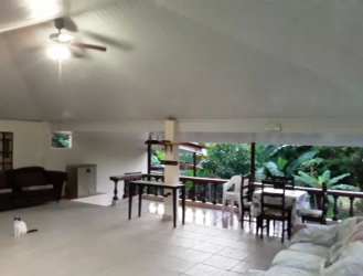 Spacious living and dining area with vaulted ceilings, tile floor, tropical views in house Panama beach Las Lajas