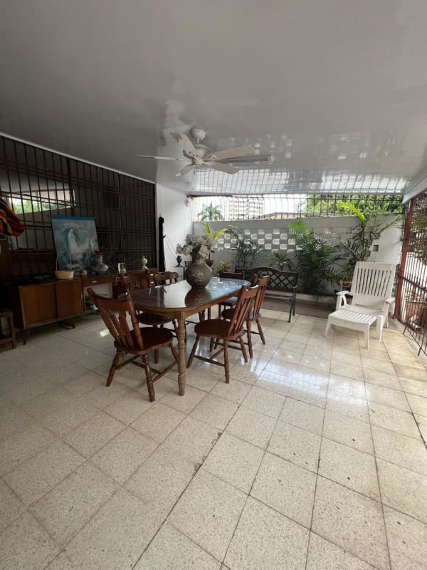 Covered outdoor patio with dining table and garden views El Carmen house Panama