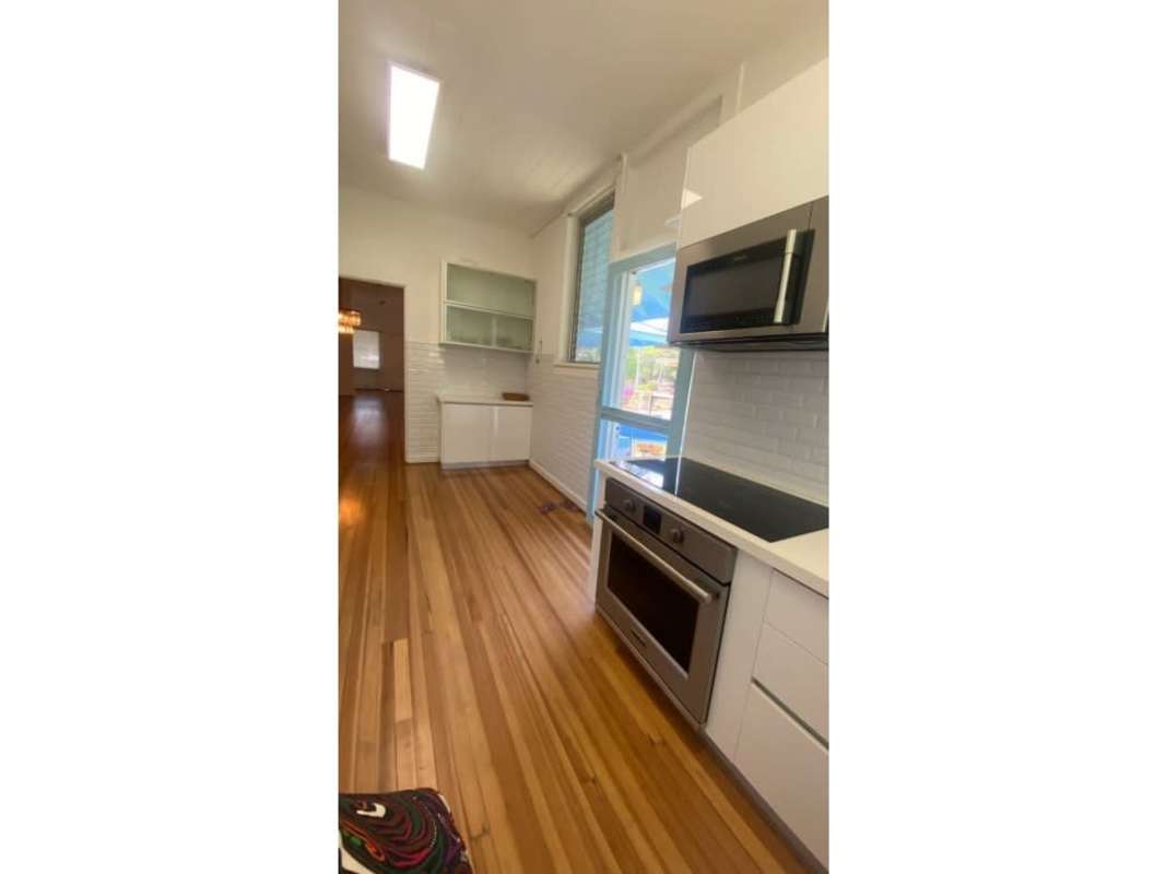 Modern gourmet kitchen with granite counters, white tile backsplash stainless steel appliances in historic Corozal house Ancon Panama