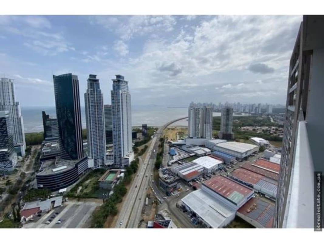 Spacious bedroom with large windows offering ocean and city views in PH Sevilla Towers