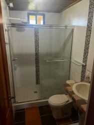 Rustic loft bedroom with wood-paneled ceiling and tile floors, Volcán Panama