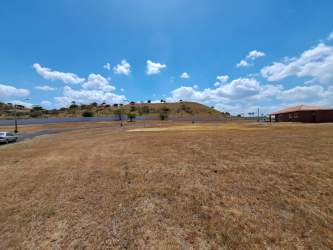 Entrance of PH Colonia El Celaje with security gate and landscaped drive in Chame Panama
