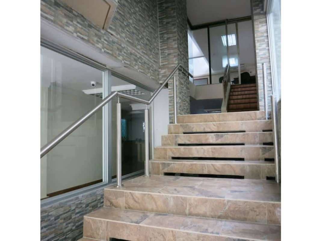 Stone-tiled stairs with metal handrails glass walls in commercial building Obarrio Panama