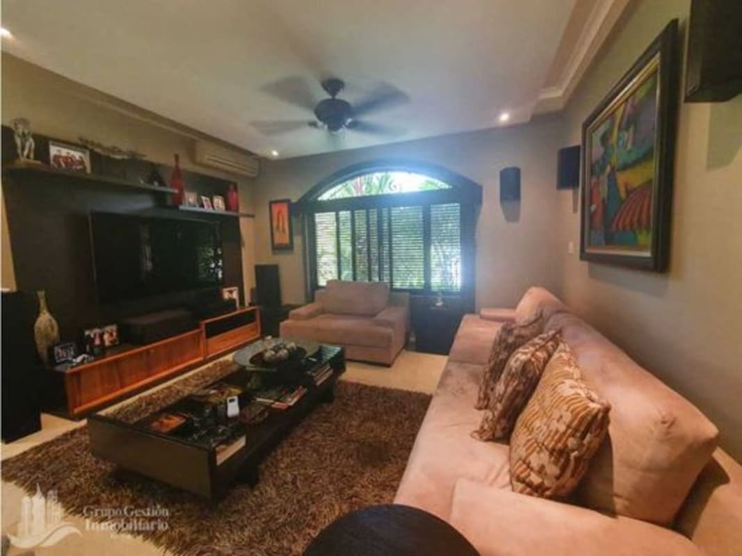 Traditional living room with sectional sofa, bookshelves and garden views