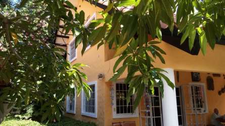 Large outdoor pool surrounded by sun deck and tropical landscaping in Villas de Coronado Panama