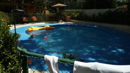 Outdoor patio with tiled roof and columns surrounded by lush greenery at Villas de Coronado Panama