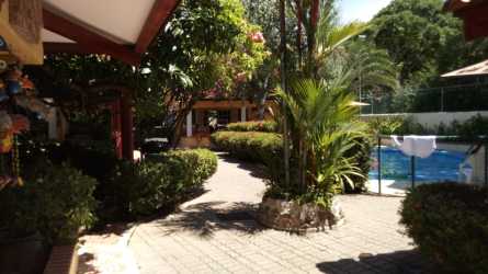 Large pool surrounded by tropical landscaping with social area and BBQ ranchos at Villas de Coronado Panama