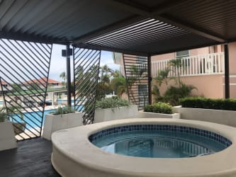 Jacuzzi covered lounge area with pool and ocean views at Coronado Panama