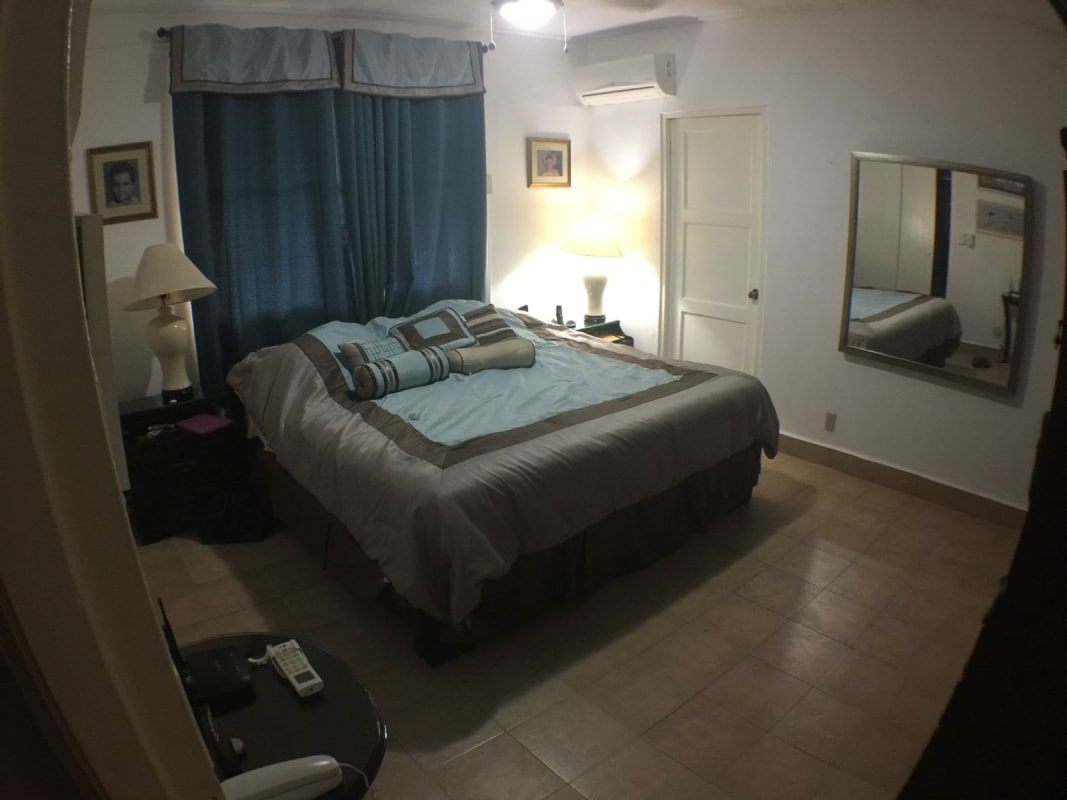 Covered outdoor terrace overlooking garden and jacuzzi in Panama City