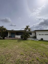 Ample garden with sheltered patio area surrounded by green trees in Chitré Panama