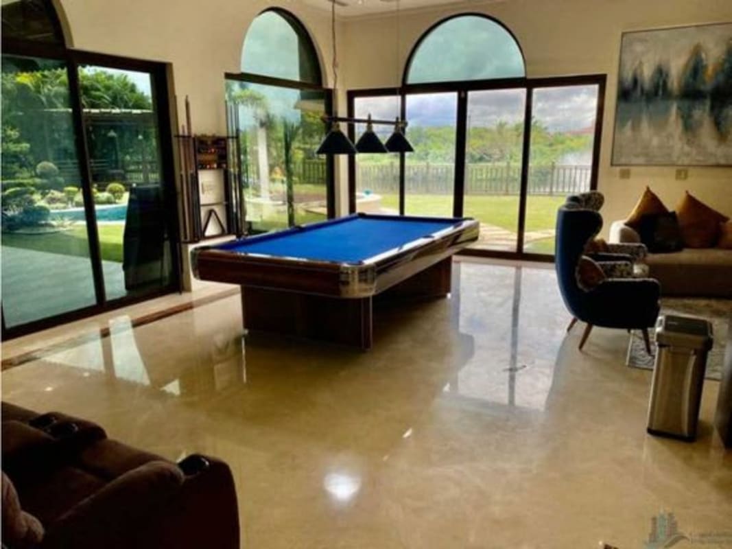 Spacious formal living room with marble floor, chandelier, balcony railings in luxury golf villa Santa Maria Panama