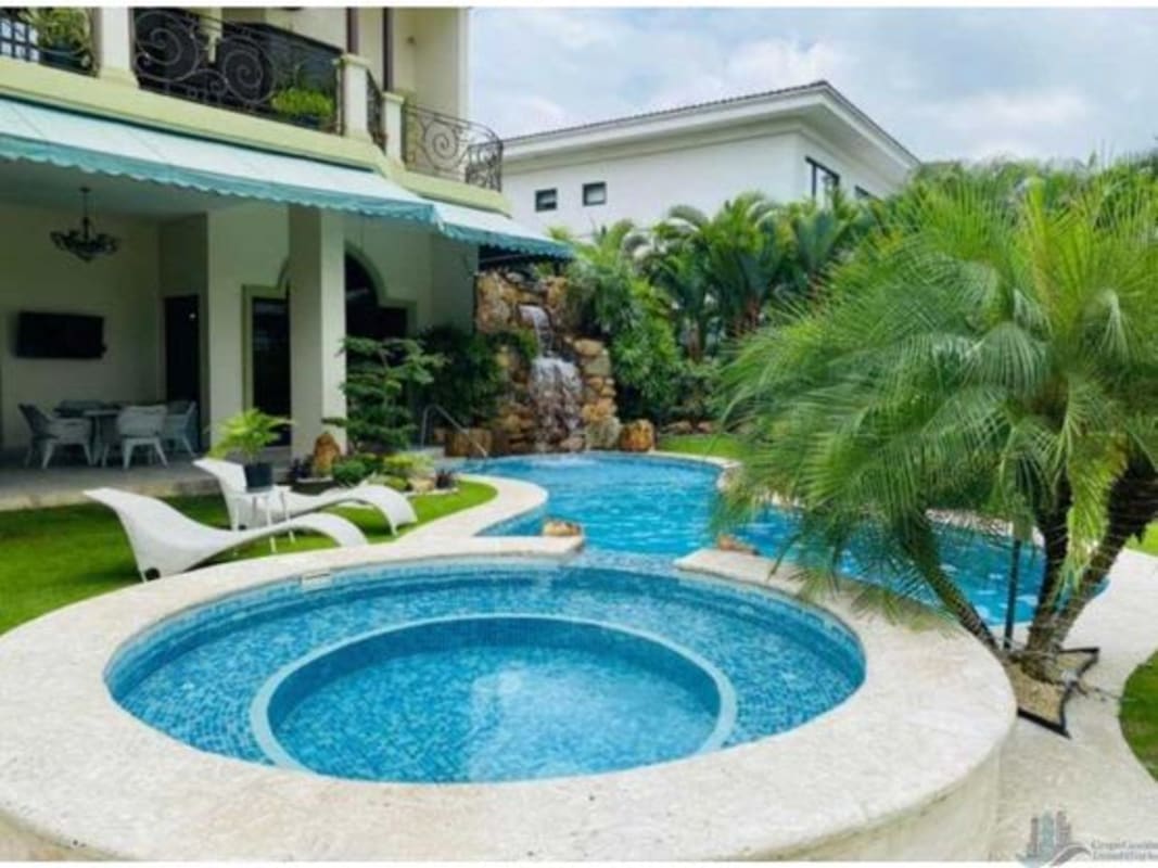 Infinity-edge swimming pool, jacuzzi, lush landscaping and lake in exclusive Panama villa rental