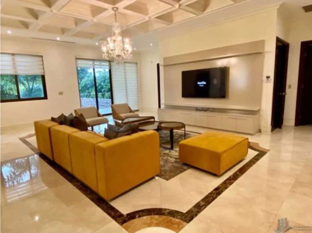 Double height living space with marble floors, chandelier and artwork in Santa Maria Panama luxury villa