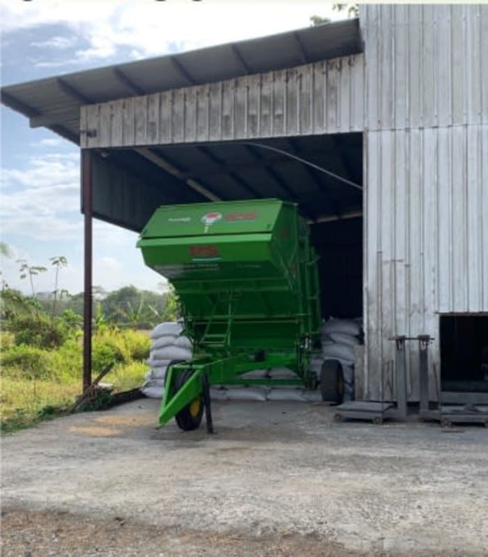 Metal shed with agricultural trailer and sacks stored by rice processing plant Chepo Panama