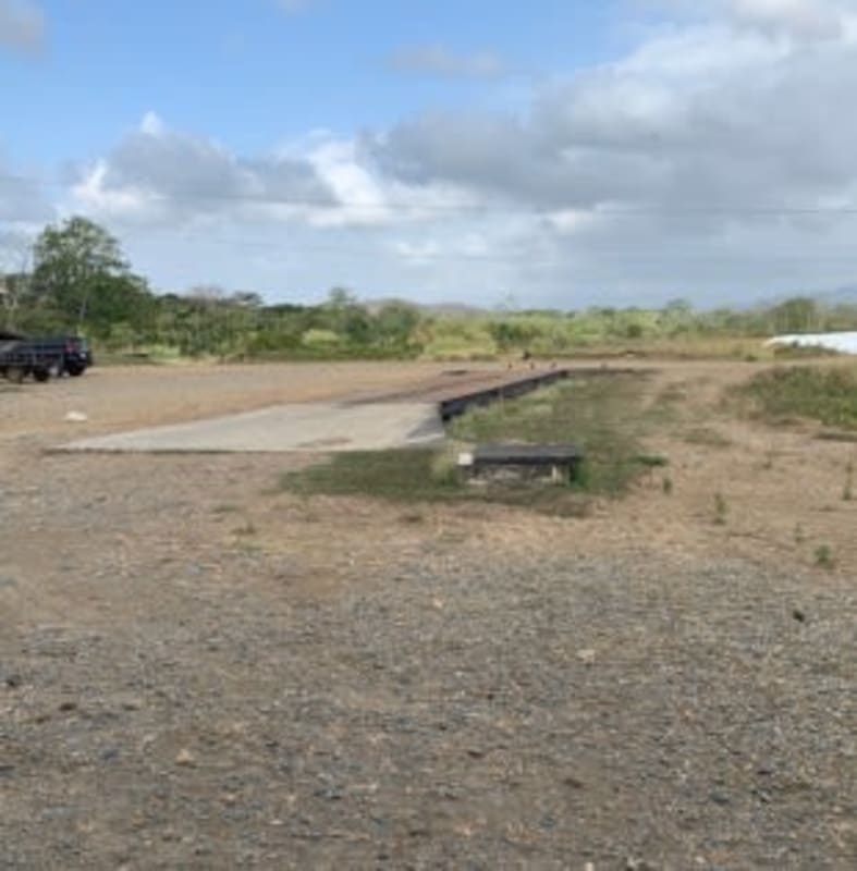 Open gravel lot and concrete area amidst greenery at agroindustrial complex Chepo Panama