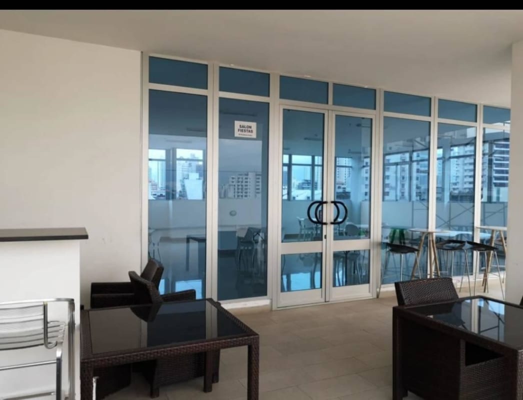 Modern party room entrance with glass doors overlooking city Costa Sur Panama