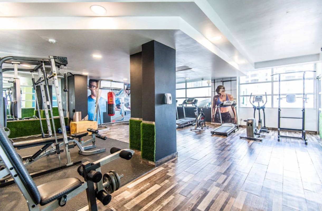 Gym with modern exercise equipment and large windows PH Ocean View Tower San Francisco Panama
