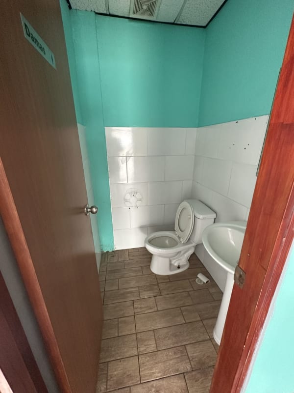 Turquoise wall small bathroom with toilet and pedestal sink in commercial space Centennial Panama
