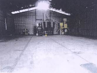 Spacious warehouse with concrete flooring and processing equipment