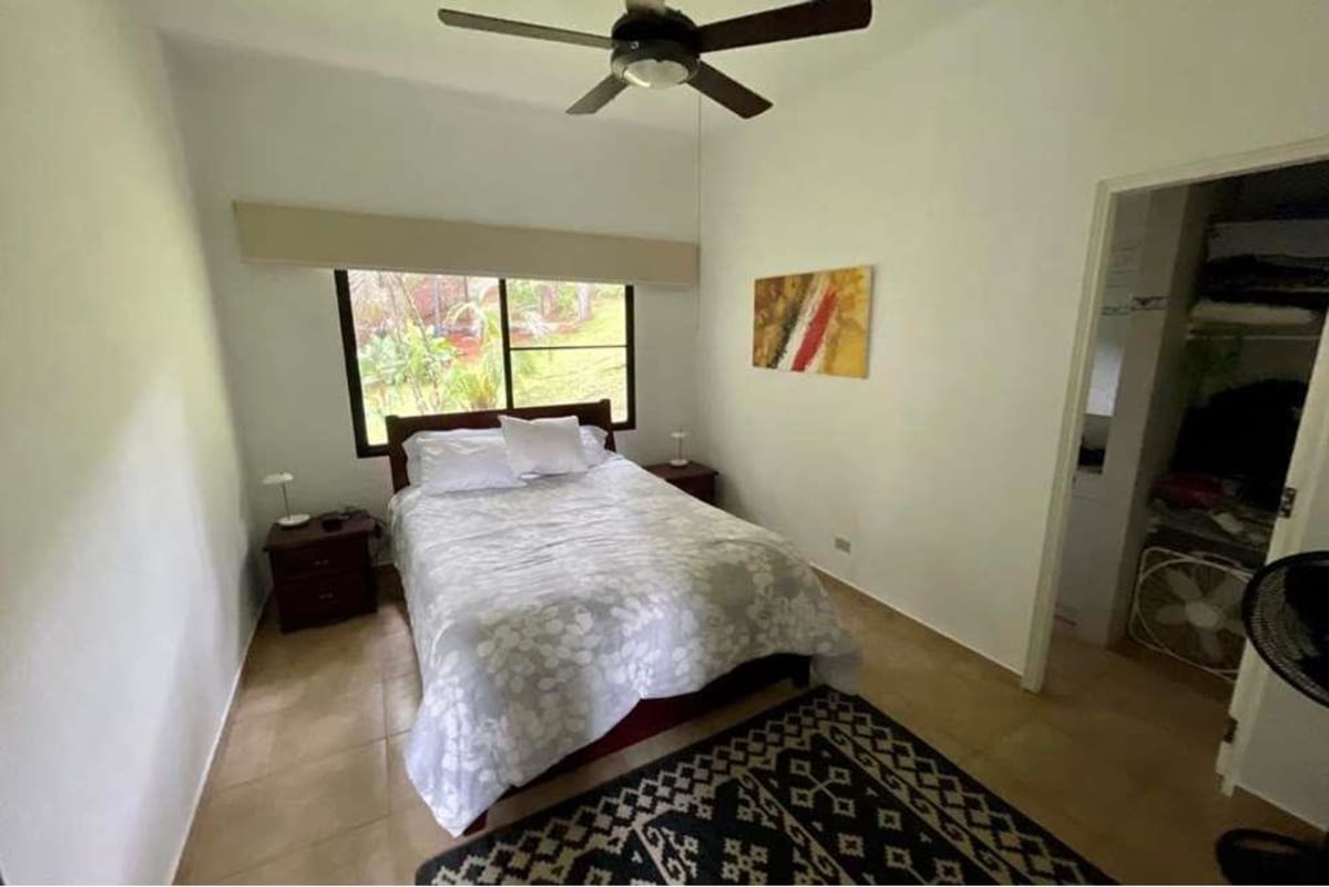Bright cozy bedroom with big windows overlooking gardens and green mountains in Cerro Azul Panama