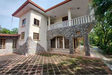 Covered terrace with columns, seating overlooking tropical gardens and swimming pool Punta Barco