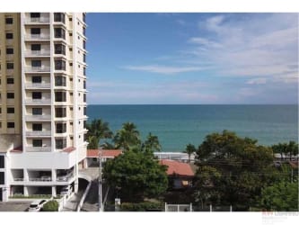 Two-story peach colored beachfront home with balconies garden carport fence in Playa Malibú Nueva Gorgona Panama