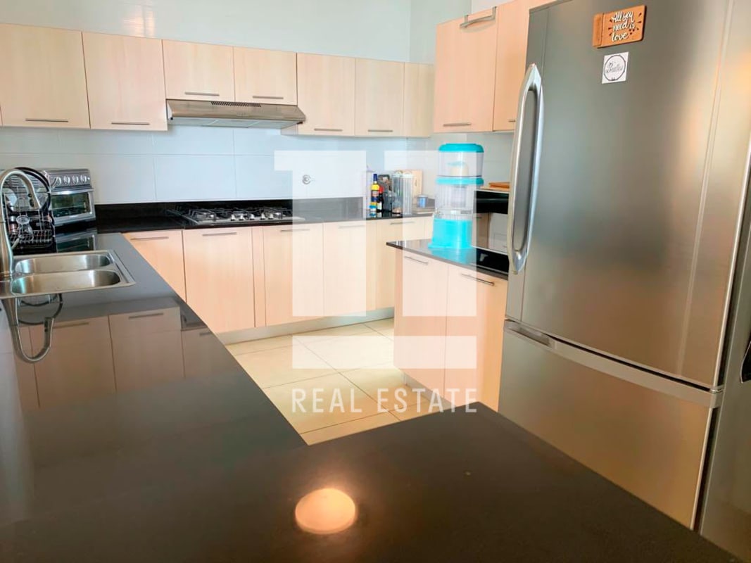 Kitchen with stainless appliances, black granite counter in Foresta Tower Panama apartment