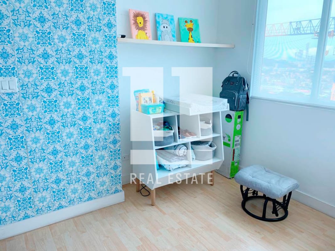 Modern living area with sectional sofa and blue wall art PH Foresta Tower Panama apartment