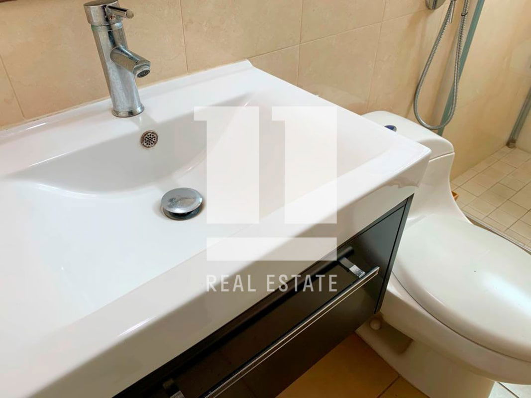 Bathroom with glass shower, white tiles, elegant sink Foresta Tower Panama