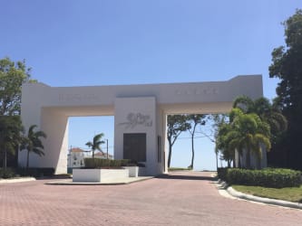 Modern gated entrance to Playa del Sol beach condos with palm landscaping
