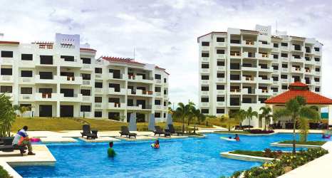 Condo buildings with red tile roofs and balconies at beachfront resort Panama