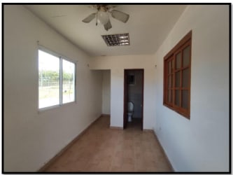 Row of mini storage warehouses with red roof on fenced commercial lot Coronado Panama