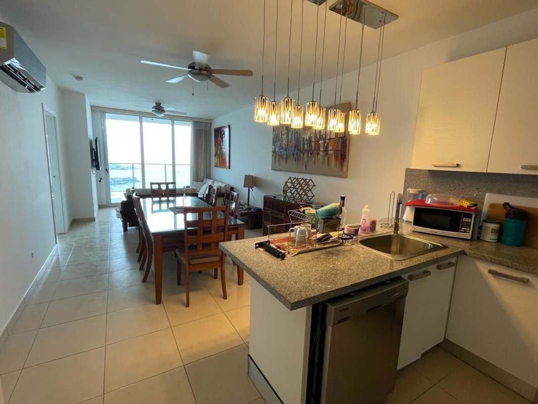 Dining space adjacent to living room with ocean skyline views in PH White Tower Panama