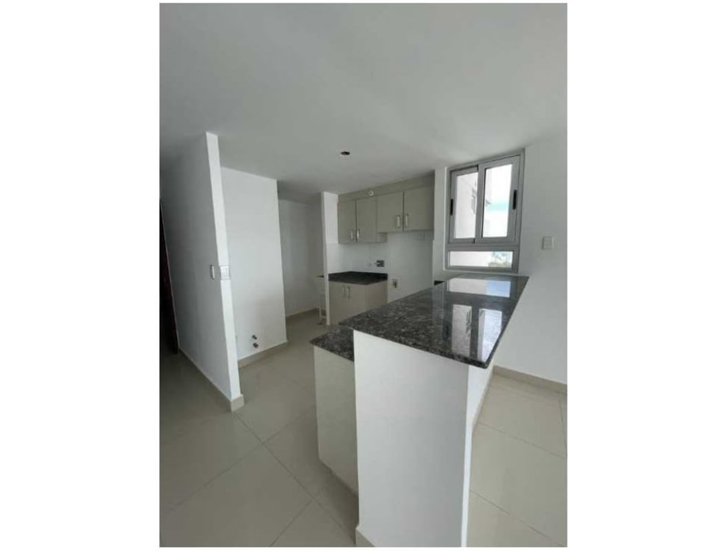 Open kitchen with granite countertops and white cabinetry Park Point Vía España Panama