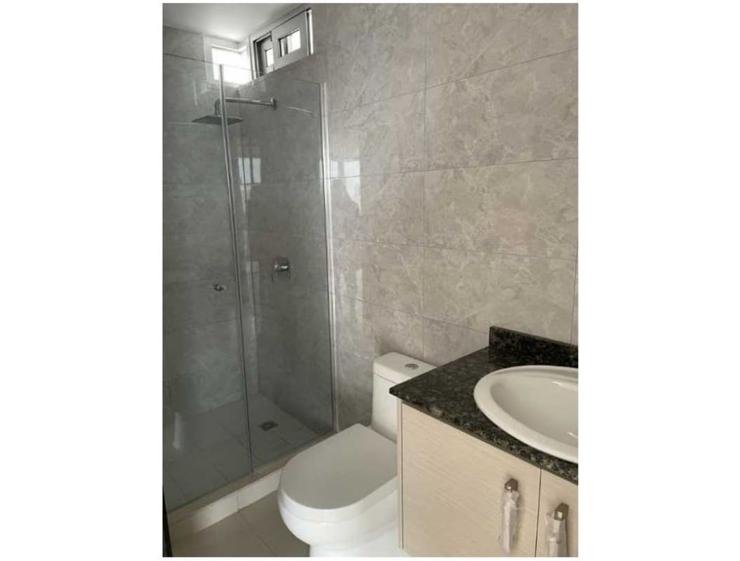 Bathroom with granite counter glass shower enclosure tiled walls Park Point Panama