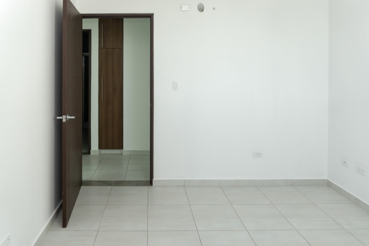 Spacious living room with large glass doors, balcony access and skyline view at PH Trinity El Carmen