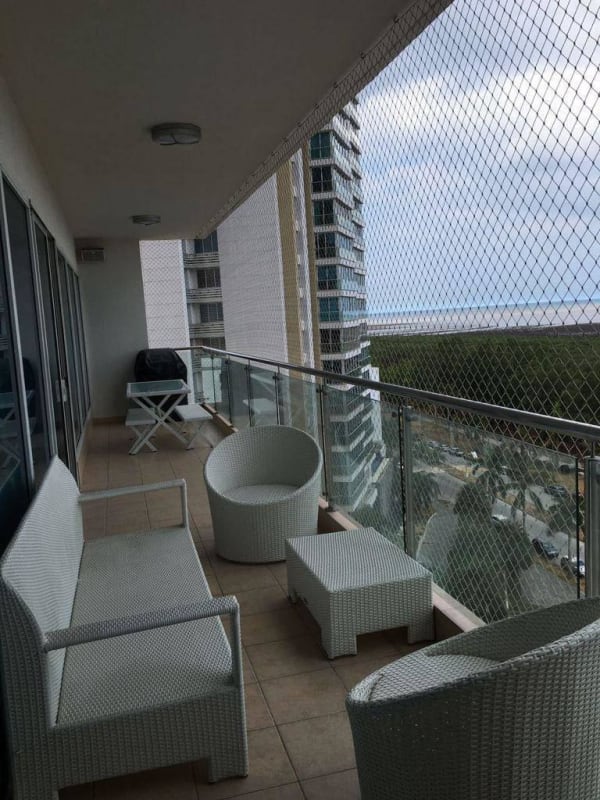 High-rise balcony with safety netting, wicker sofas, and ocean view in PH Zeus Costa del Este