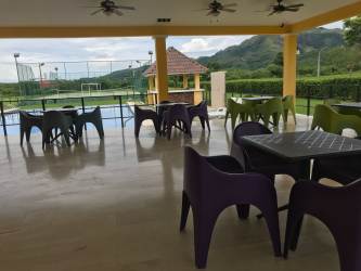 Wide grassy lot with trees and plot signage in gated community Chame Panama