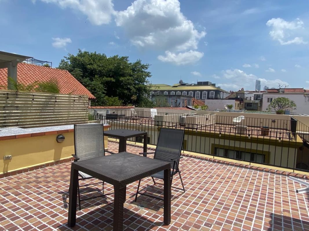 Dining living space with rustic brick wall, colorful chairs Casco Viejo Panama