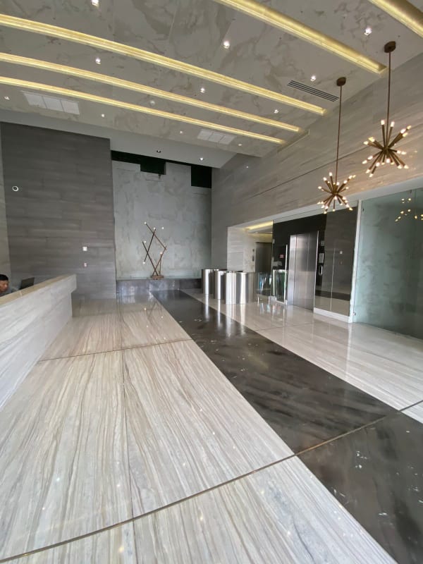 High-ceiling marble lobby with chandeliers, reception desk, elevators in The Towers San Francisco Panama City