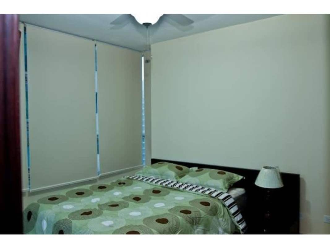 Bedroom with ceiling fan, large windows covered with blinds and minimalist design in PH Top Towers Costa del Este Panama