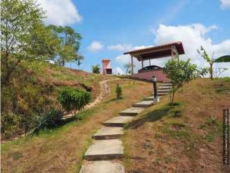 Rustic outdoor patio with stone pathway, barbecue area, fireplace, garden in Trinity Hills Valley Campana Panama