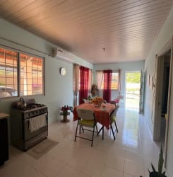 Bathroom with white tiles, pedestal sink, and toilet in house for sale in Rancho Los Sueños Panama